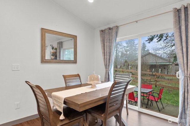 dining room with lofted ceiling and hardwood / wood-style floors