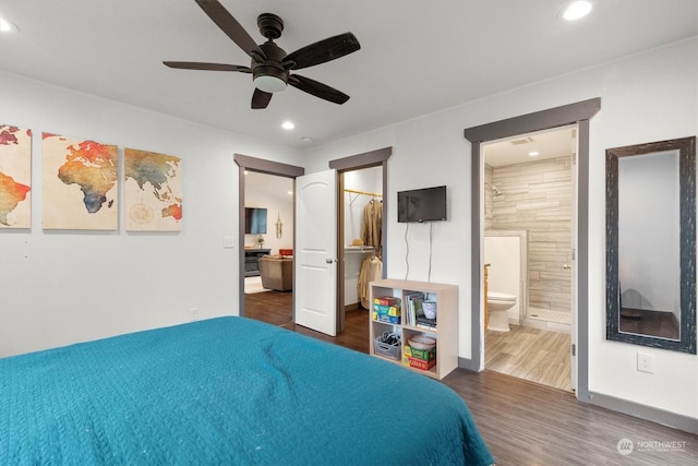 bedroom with a spacious closet, connected bathroom, dark hardwood / wood-style floors, a closet, and ceiling fan