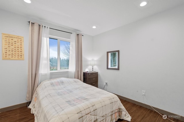 bedroom with dark hardwood / wood-style flooring