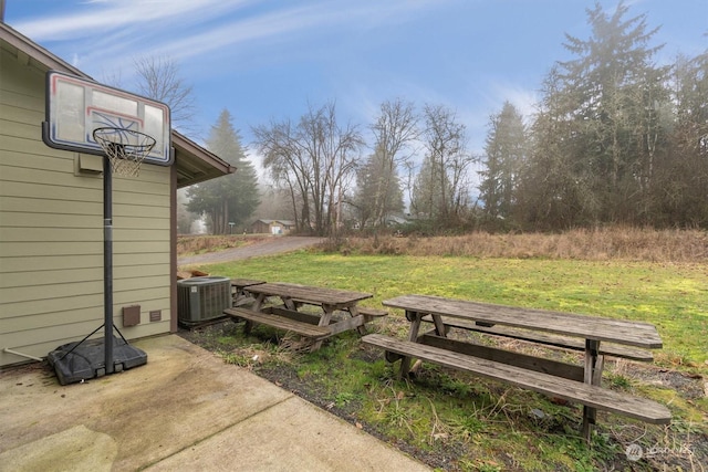 view of yard with central AC and a patio