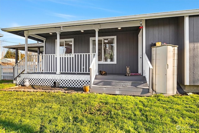 entrance to property featuring a yard and a porch