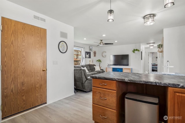 kitchen featuring ceiling fan, light wood-type flooring, and decorative light fixtures