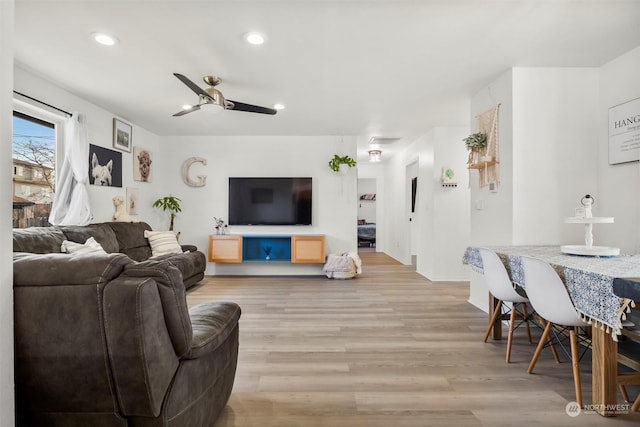 living room with ceiling fan and light hardwood / wood-style flooring