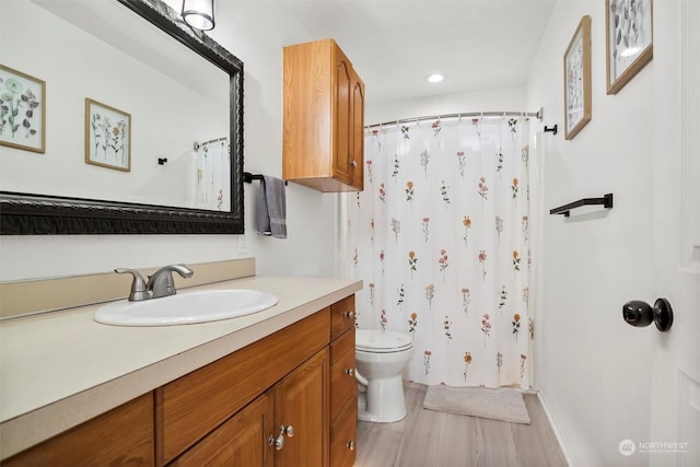 bathroom with toilet, vanity, wood-type flooring, and a shower with curtain