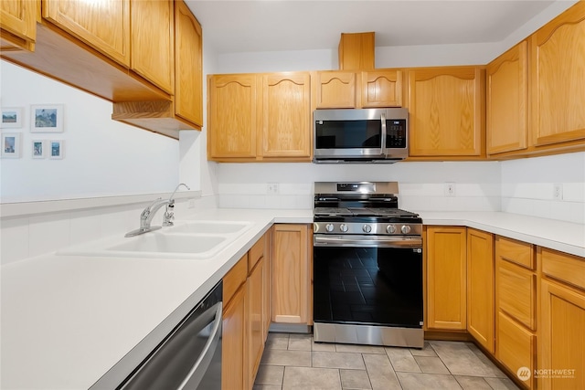 kitchen featuring sink, light tile patterned floors, and stainless steel appliances