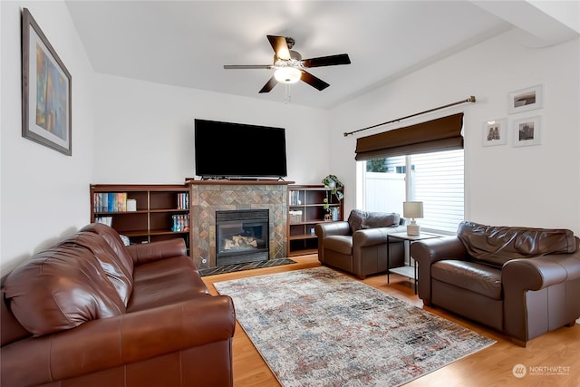 living room with ceiling fan, light wood-type flooring, and a fireplace