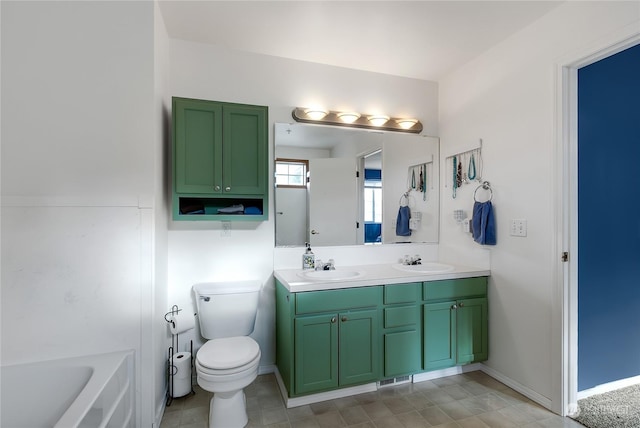 bathroom with toilet, vanity, and a bathtub