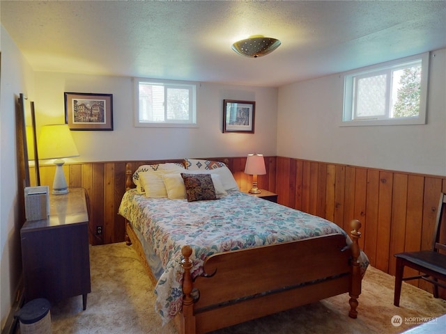 carpeted bedroom featuring a textured ceiling and wooden walls