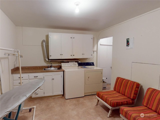 washroom featuring cabinets, sink, and washing machine and dryer