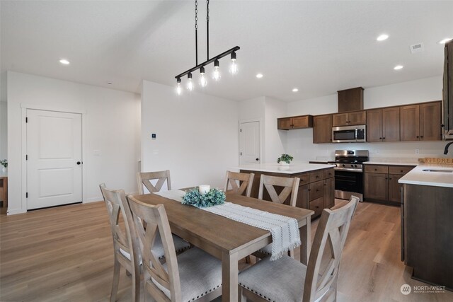 dining area with light hardwood / wood-style flooring and sink