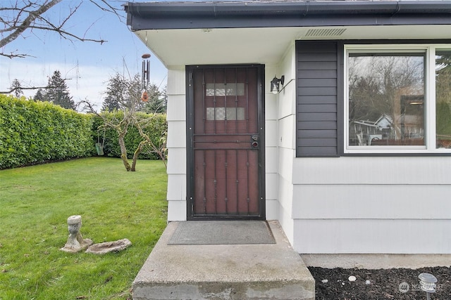 doorway to property with a lawn