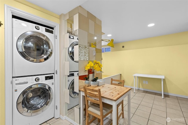 laundry room featuring light tile patterned floors and stacked washer and dryer