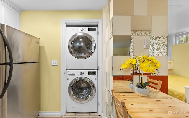 washroom with light tile patterned floors and stacked washing maching and dryer