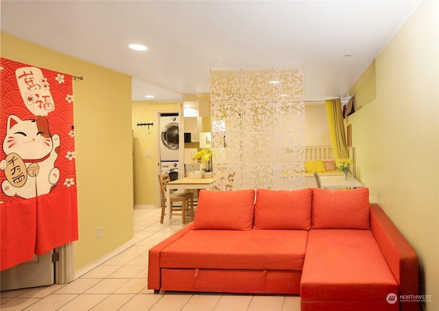 living room featuring light tile patterned flooring and stacked washer / dryer