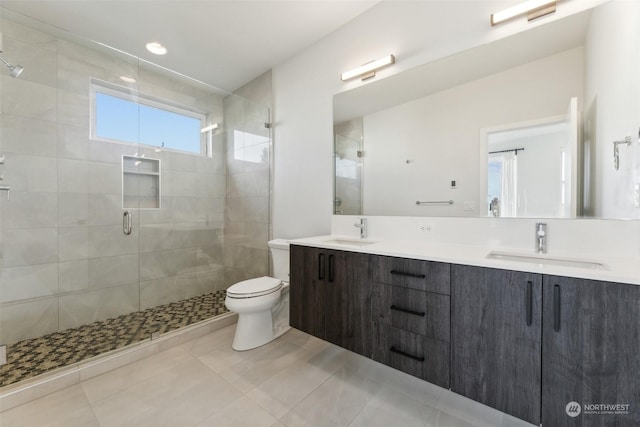 bathroom featuring a shower with door, tile patterned floors, toilet, and vanity