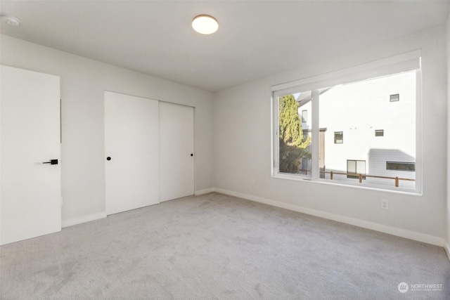 unfurnished bedroom with a closet and light colored carpet