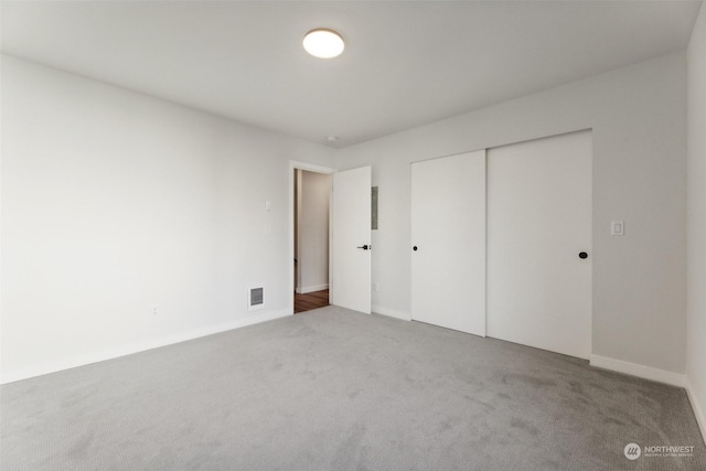 unfurnished bedroom with a closet and carpet flooring