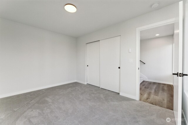 unfurnished bedroom with a closet and light carpet