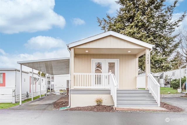 manufactured / mobile home featuring a carport and covered porch