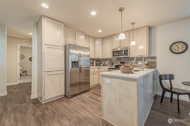 kitchen featuring stainless steel appliances, pendant lighting, decorative backsplash, and kitchen peninsula