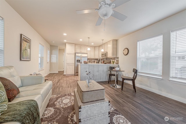 living room with hardwood / wood-style flooring, ceiling fan, and sink