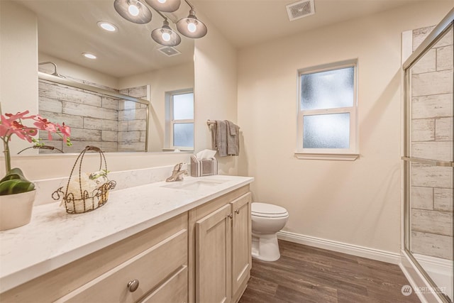 bathroom featuring hardwood / wood-style flooring, vanity, toilet, and walk in shower