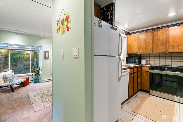 kitchen with light tile patterned flooring, white appliances, and tasteful backsplash