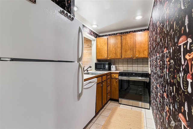 kitchen with light tile patterned floors, decorative backsplash, sink, and white appliances