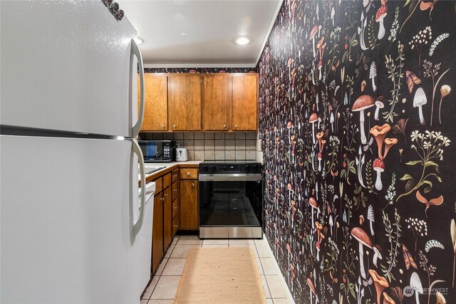 kitchen with light tile patterned floors, decorative backsplash, and white appliances