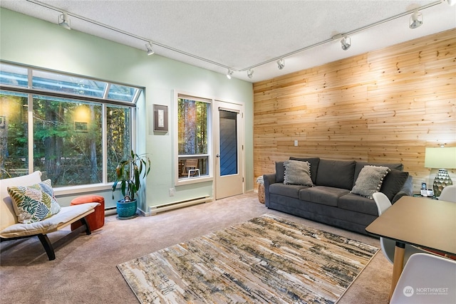 carpeted living room with baseboard heating, a textured ceiling, and wooden walls