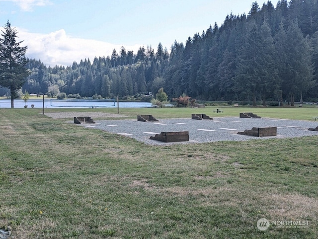 view of property's community featuring a lawn and a water view