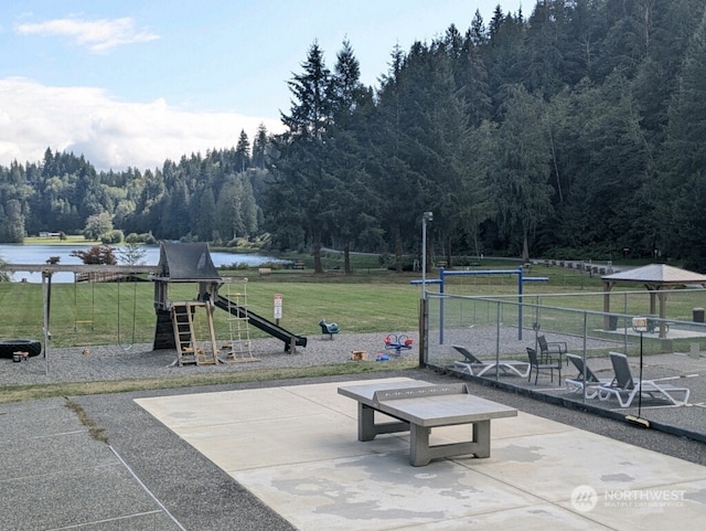 view of patio featuring a playground and a water view