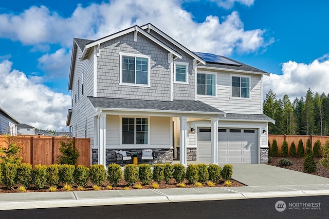 craftsman house with solar panels, a porch, and a garage