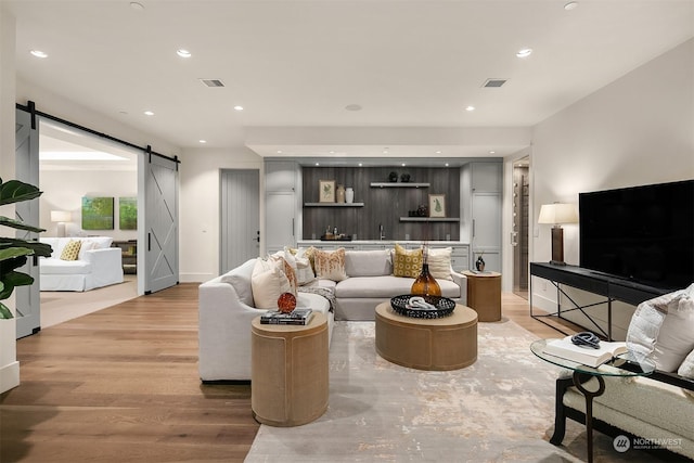 living room with hardwood / wood-style flooring and a barn door