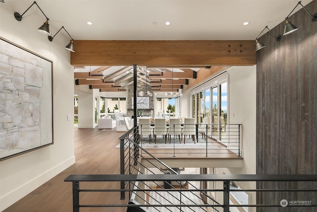 stairway featuring beam ceiling and hardwood / wood-style floors