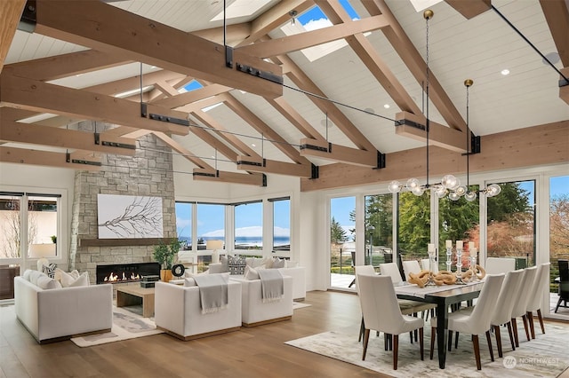 sunroom / solarium with lofted ceiling with beams, wooden ceiling, a notable chandelier, and a fireplace