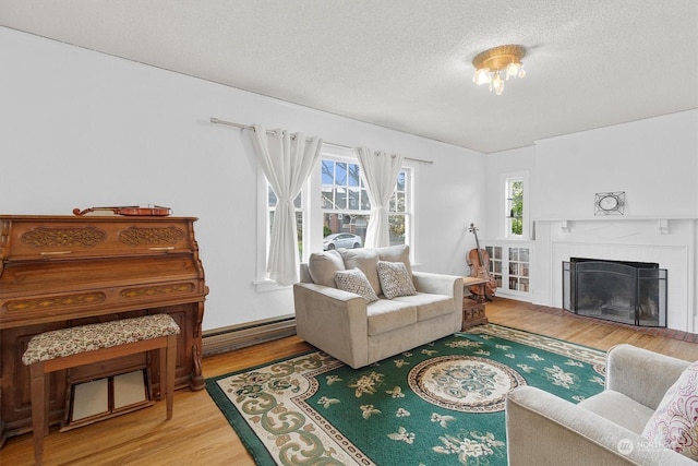 living room with a baseboard radiator, hardwood / wood-style floors, a textured ceiling, and a fireplace