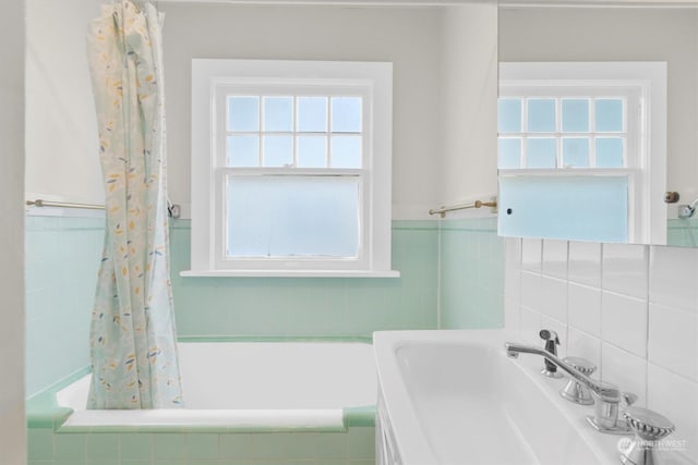 bathroom with sink, a wealth of natural light, and shower / bath combo