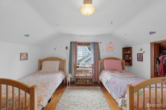 bedroom featuring hardwood / wood-style floors and vaulted ceiling