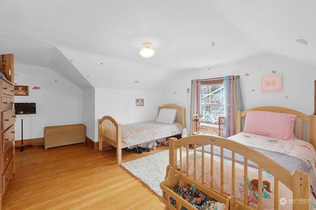 bedroom featuring light hardwood / wood-style flooring and lofted ceiling