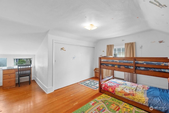 bedroom featuring light hardwood / wood-style flooring, a closet, and lofted ceiling