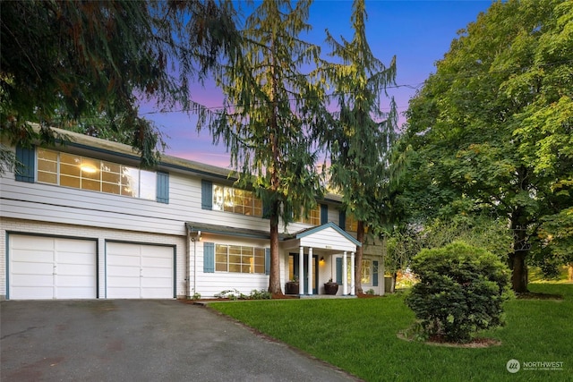 view of front facade with a garage and a lawn