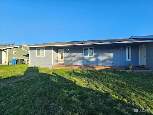 back of property with a lawn and a patio