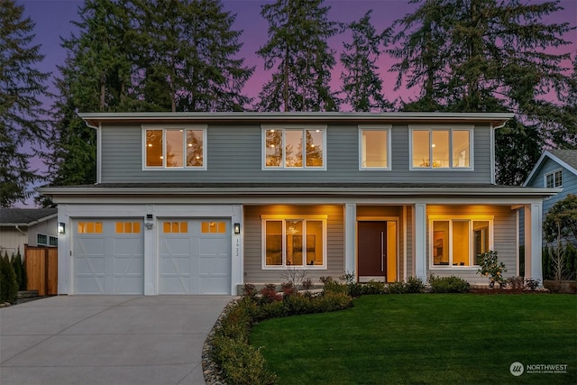 view of front of property with a garage and a yard