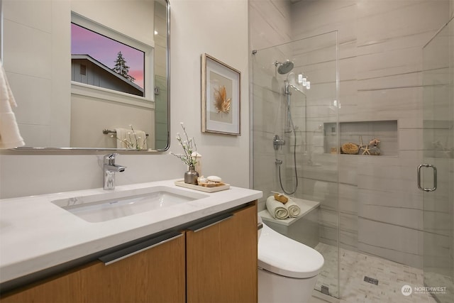 bathroom with a shower with door, toilet, and vanity