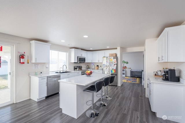 kitchen featuring white cabinetry, sink, a breakfast bar area, a center island, and stainless steel appliances