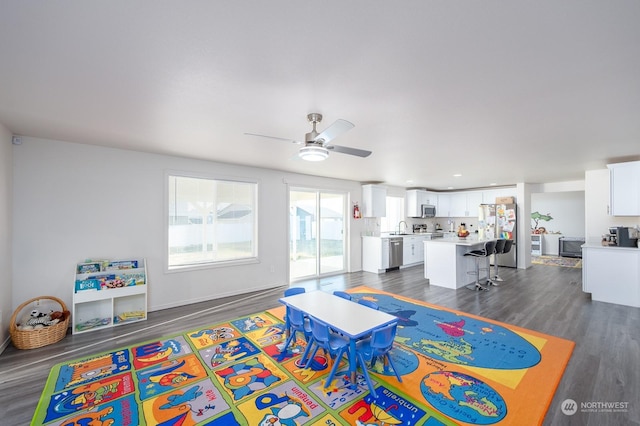 playroom with dark wood-type flooring, sink, and ceiling fan