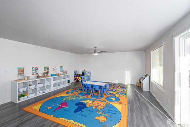 recreation room with dark wood-type flooring, a wealth of natural light, and ceiling fan