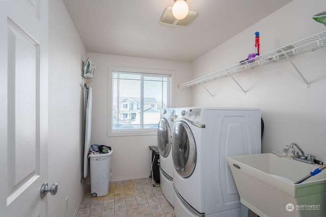 clothes washing area featuring sink and washer and dryer