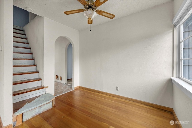 empty room featuring ceiling fan, a wealth of natural light, and hardwood / wood-style flooring